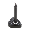 Black talking board planchette-shaped spell candle holder with a black spell candle, featuring sun and celestial engravings