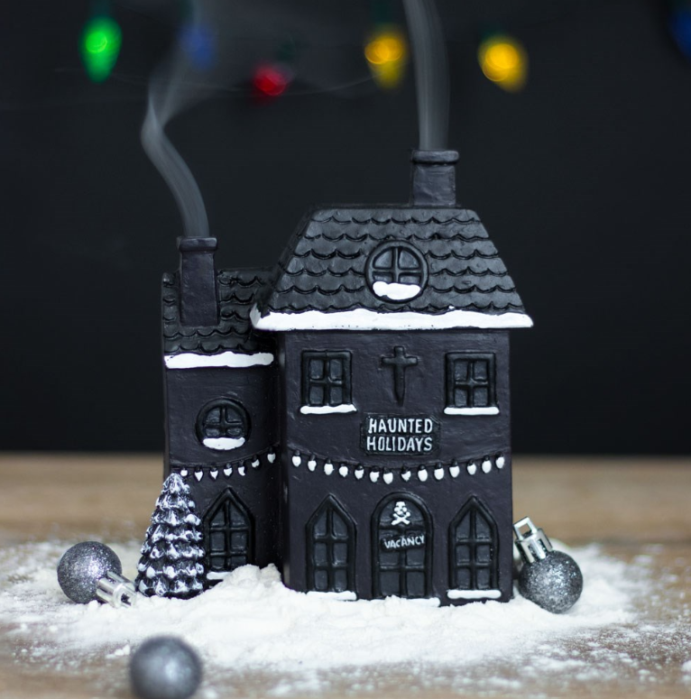 Black haunted house incense cone burner with ghost and cobweb details and smoke rising from two chimneys, gothic Christmas decor