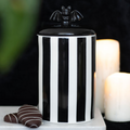 Black-and-white striped ceramic bat storage jar with a lift-off bat-detail lid.
