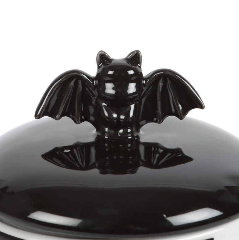 Black-and-white striped ceramic bat storage jar with a lift-off bat-detail lid.