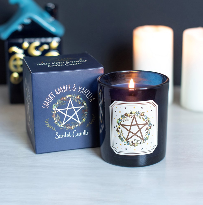 Smoky Amber and Vanilla Solstice Wreath scented candle in glossy navy glass jar with matching navy gift box showing pentagram wreath design