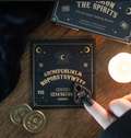 Mini black and gold ouija talking board and teardrop planchette inside open matchbox-style gift box