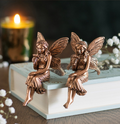 Set of 2 bronze-effect resin fairy shelf sitter ornaments displayed on a shelf